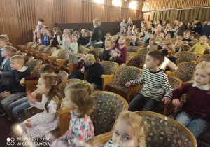 Dzieci w teatrze oglądają przedstawienie.